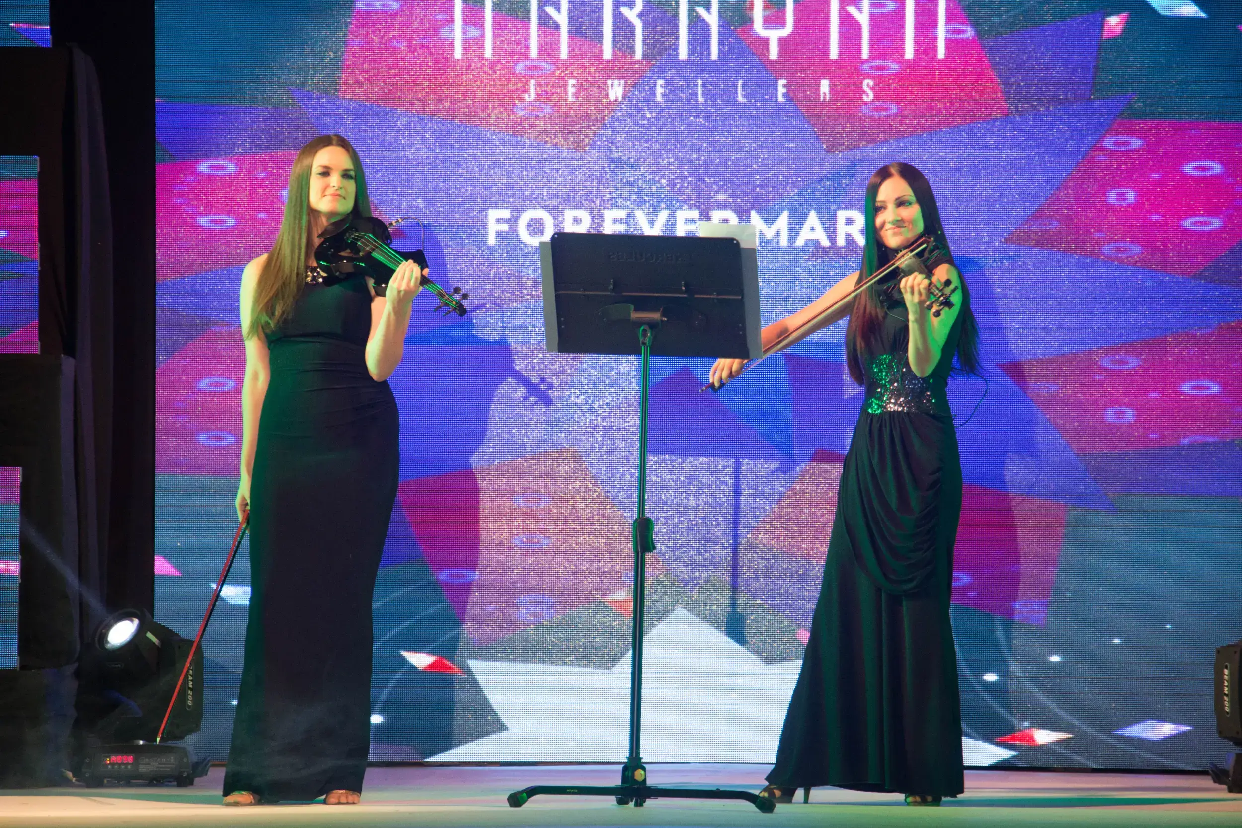 ITT event entrance with red and green carpet and pink lighting on white structure with ITT branding